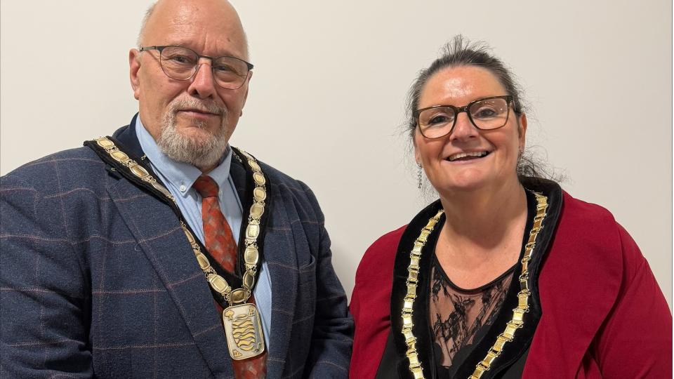 David Moore and Debbie Darby stood next to each other wearing their Chair and Vice Chair decorative chains around their necks
