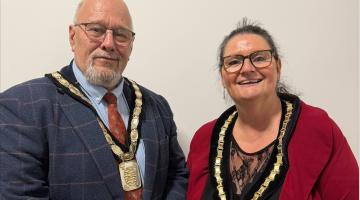 David Moore and Debbie Darby stood next to each other wearing their Chair and Vice Chair decorative chains around their necks