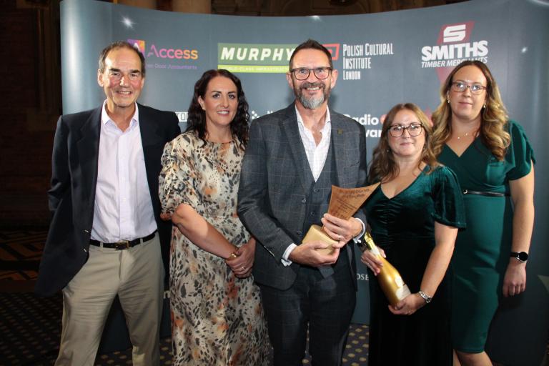 Recycling Ollerton and Boughton smiling holding award trophy and prosecco bottle.